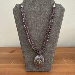 Purple beaded necklace with large shell pendant